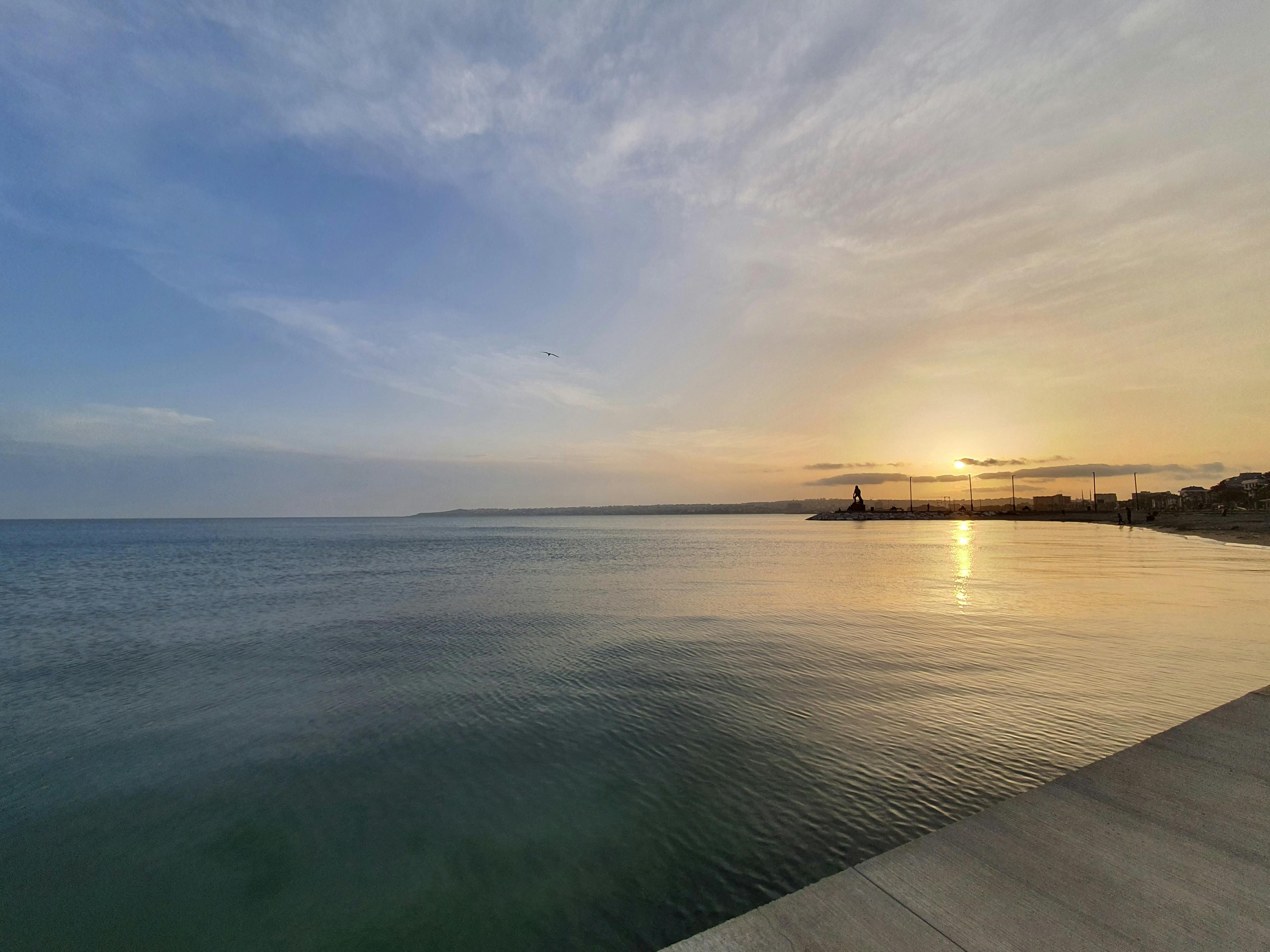 Peaceful coastal sunset over calm waters, representing hope and new beginnings